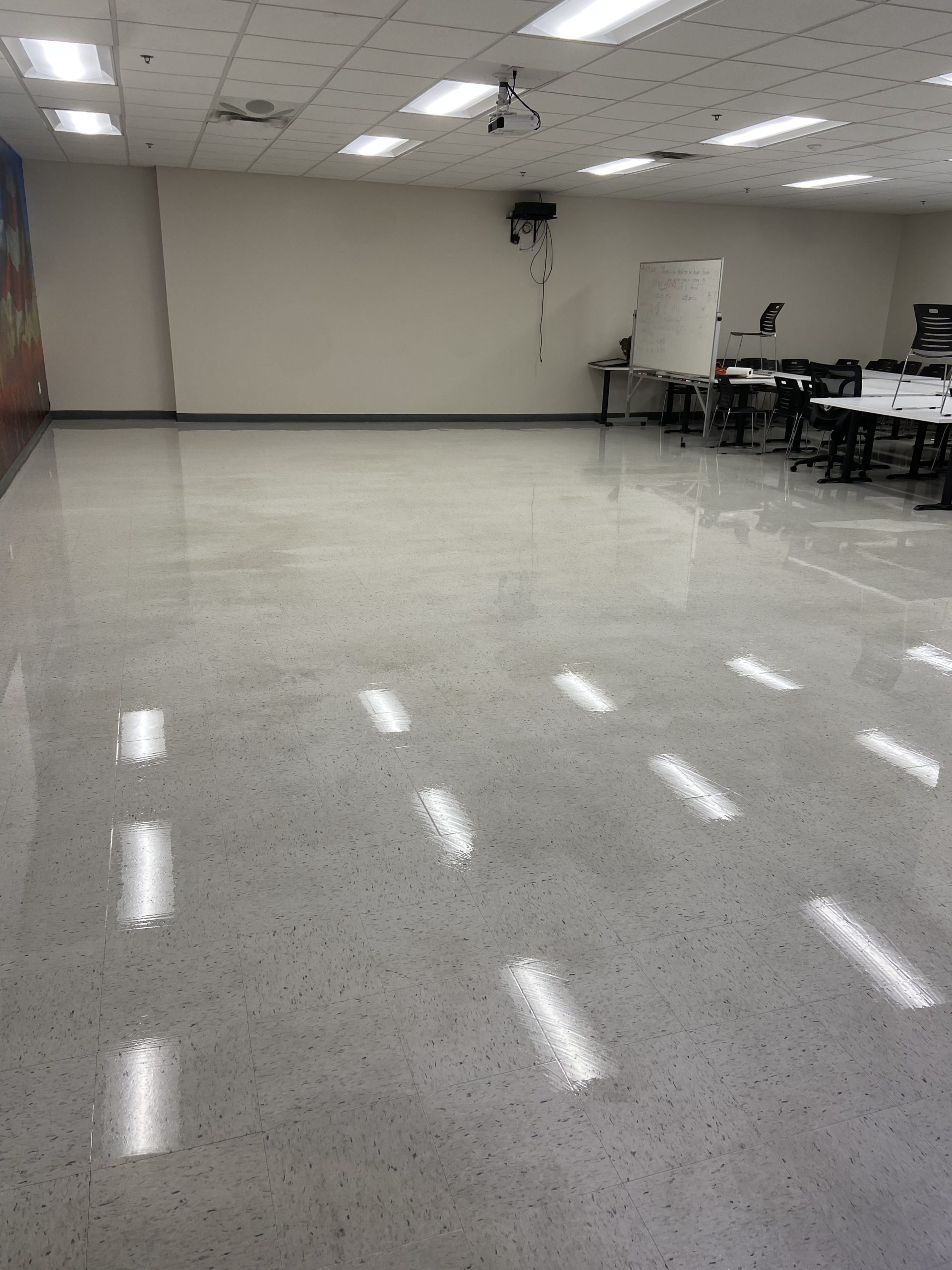 A room cleaned by PCR Services illustrates the company's dedication to top-tier cleaning services with a freshly cleaned floor that reflects the lights above it.
